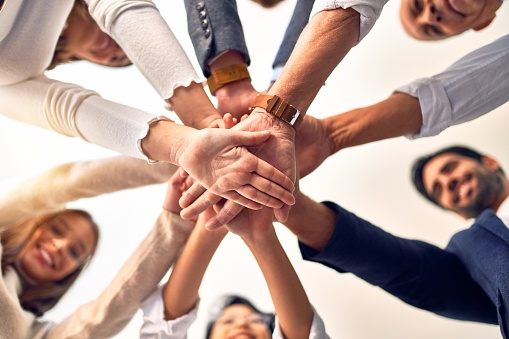 Group of business workers standing with hands together at the office